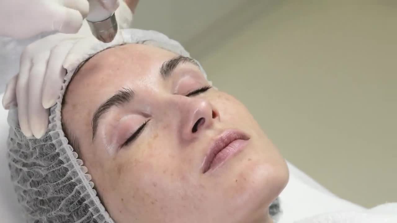 A client during an LED and cryo facial treatment in a bright clinical room